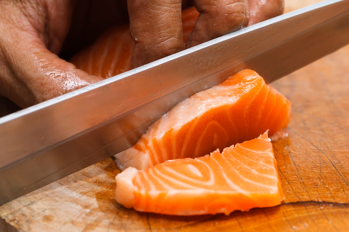 Een man snijdt zalm.